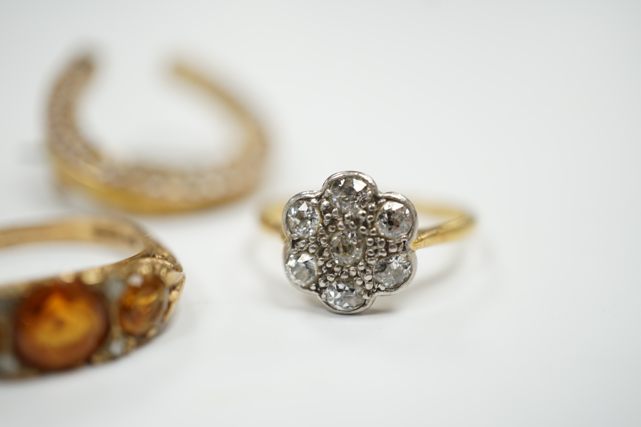 A 1920's 18ct, plat and millegrain set diamond flower head cluster ring, size L/M, a later 9ct gold and three stone citrine ring, with rose cut diamond chip spacers and a yellow metal seed pearl cluster set horseshoe bro